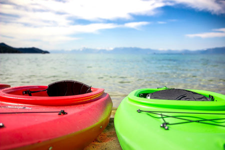 Colorful kayaks resting by the lakeの写真素材