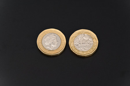 GBP British one pound coins currency on a Black backgroundの写真素材