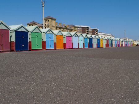 Brightly coloured beach huts on esplanade foreground.の写真素材