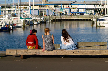 Wellington, New Zealand, October 4 2010, friends sitting on the dockのeditorial素材