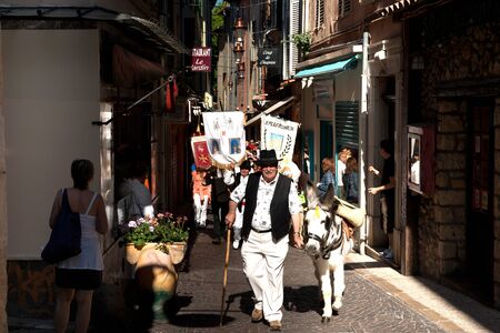 Antibes, France, May 1st 2011Man dressed traditionally leads a donkey in Labor Day march in Antibes, france.のeditorial素材