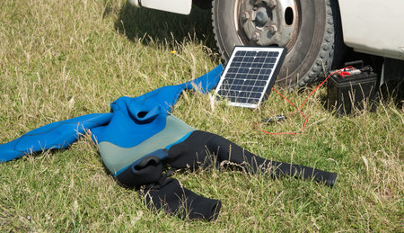 Portable solar panel charging a vehicle battery.