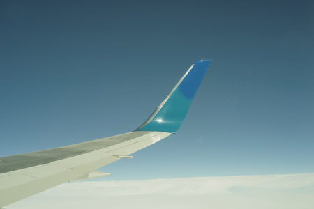 Airliner wing projects into blue sky 