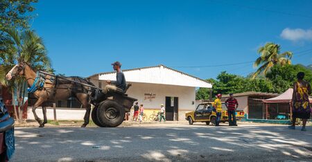 PINAR DEL RIO - CUBA - JULY 3; man on horse and cart pass through small town  on country road in Pina Del Rio, cuba on July 3, 2012. This mode of transport is common in Cuba.のeditorial素材
