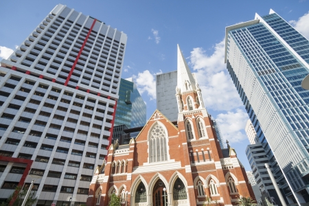 Low angle view of traditional church and high rise buildings の写真素材