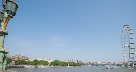 The River Thames, framed by street lamp on Westminster Bridge and the ferris wheel 