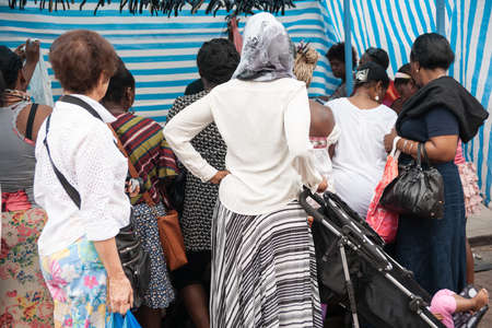London, England; Group watch a market vendor in the  famous Roman Road Street Market のeditorial素材