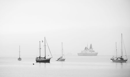 Misty scene, boats on calm harbour の写真素材