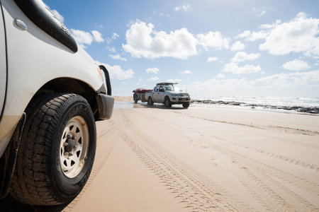 Fraser Island, Australia - March 13, 2014 Tourists drive in foru wheel drive vehicles along Fraser...