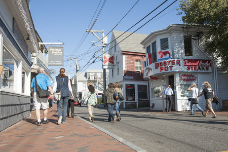 PROVINCETOWN, USA - OCTOBER 18, 2014; People wander along Commercial Street enjoying a summer day and the shops. A small quaint tourist town on Cape Cod.のeditorial素材