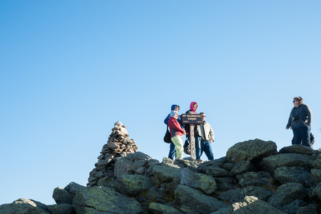 MOUNT WASHINGTON, USA - OCTOBER 7, 2014; Group of travelers stand on peak of mountain taking photos by the name signのeditorial素材