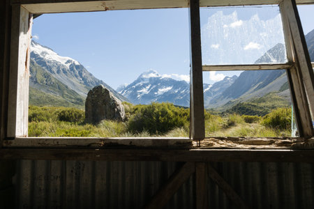 Mount Cook, in the distance with Hookers Track foreground through an historic old trampers hut...