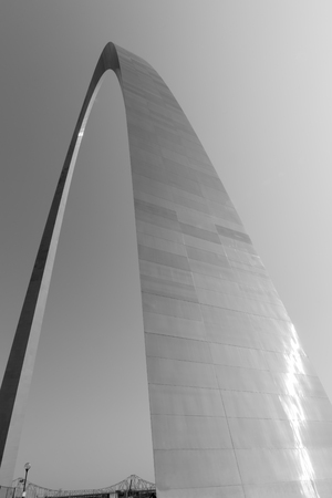 St Louis Gateway Arch catches sun glistening as it towers into clear  sky with Martin Luther truss Bridge bottom of image. Abstract masterpiece of St Louis architecture, and famous arch, Missouri,USA.のeditorial素材