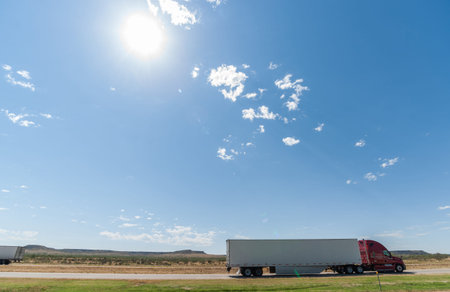 Hot sun shines across Texan landscape while trucks passing in interstate 40 mesa landforms on...