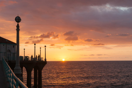 Silhouettes of people gathered to experience sunset over ocean from Manhattan Beach pier watching sunset sunset Californiaの写真素材