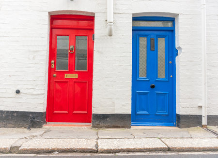 Two traditional style doors together different colors facing the street
