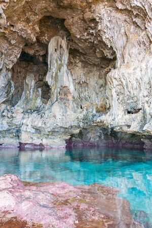 Calm turquoise colored water in coral rock pool in limestone  cave on coast of Niue.の写真素材