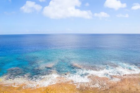 Pacific Ocean beyong coral shoreline and  distant horizon and below sky.の写真素材