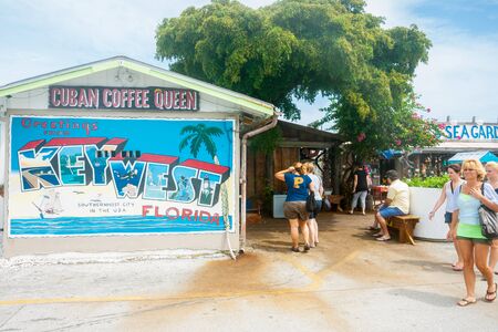 Key West, Florida, USA - June 26, 2012;  Large cafe sign with greetings from Key West message and tourists walking byのeditorial素材