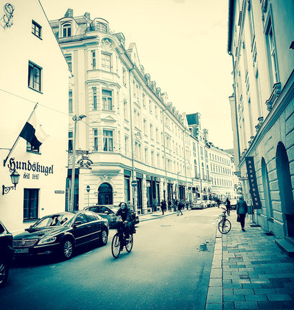 MUNICH, GERMANY- SEPTEMBER 8, 2017  Gritty mobile phone, Instagram effect of people on street with woman on bicycle approaching retro Instagram effectのeditorial素材