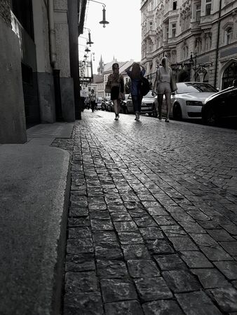 PRAGUE, CZECH REPUBLIC, - AUGUST 30, 2017; Women walking away in Old City street in Prague early evening light glistens on cobbles as light fades.のeditorial素材