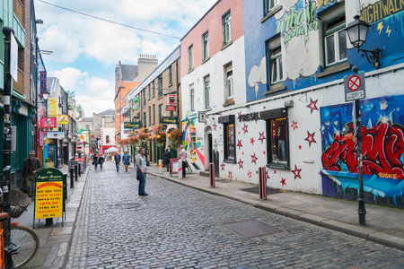 DUBLIN, IRELAND - AUGUST 10, 2017; Few people leisurely browsing and walking  along narrow quaint...