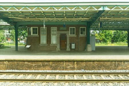 VROUWEN, GERMANY - AUGUST 24, 2017; Gritty image small town  Old fashioned German style railway station structure with nobody and old brick office under veranda roofのeditorial素材