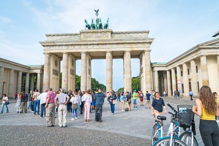 BERLIN, GERMANY - AUGUST 25, 2017; Group of in front tourists gather as others arrive in large numbers daily to see and photograph the symbol of old Cold War the Brandenburg Gateのeditorial素材