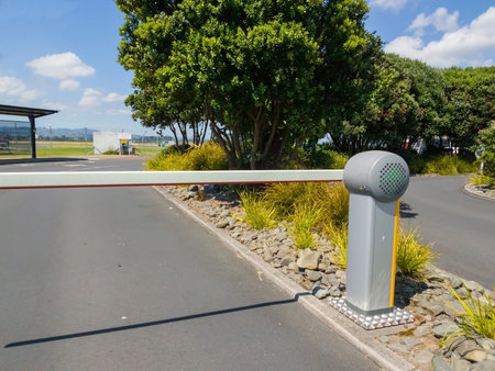 Car Park sign, barrier arm on entrance road lined with trees.