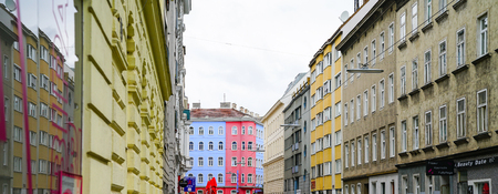 VIENNA,AUSTRIA - SEPTEMBER 3 2017; European street lined both sides with buildings converging to bright  pink and blue building at end.のeditorial素材