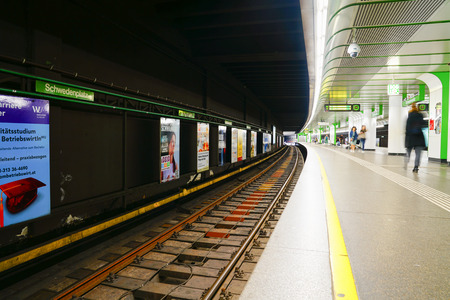 VIENNA,AUSTRIA - SEPTEMBER 4 2017; Urban transport railway station yellow line on platform and people moving about waiting.のeditorial素材