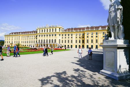 VIENNA,AUSTRIA - SEPTEMBER 4 2017; Tourists arriving ai morning walking past lawn and formal gardens in front baroque architectural detail of the Schonbrunn imperial palace, one of the major tourist attractions in Vienna, Austriaのeditorial素材