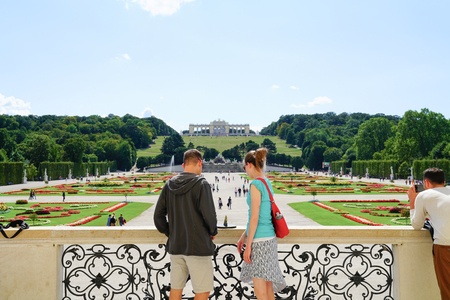 VIENNA,AUSTRIA - SEPTEMBER 4 2017;  Young couple tourists  view  gardens  leading to Neptune Fountain and Gloriette in landscaped grounds of Schonbrunn Imperial Palaceのeditorial素材