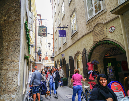 SALZBURG, AUSTRIA - SEPTEMBER 6 2017; People moving through busy narrow street of historic buildings and modern shops in old cityのeditorial素材