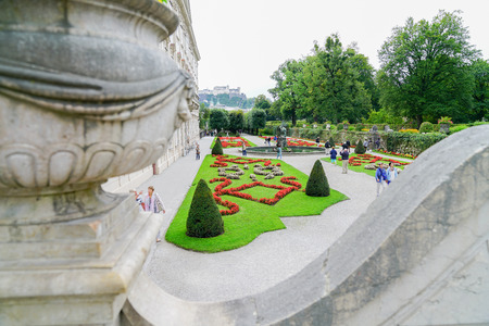 SALZBURG AUSTRIA _ SEPTEMBER 6 2017; Tourists enjoy walking in the beautiful Mirabell Gardens viewd from elevated walkway  with palace building on left.のeditorial素材
