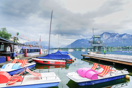 MONDSEE AUSTRIA-SEPTEMBER 6 2017; Boats ready for hire and waiting tied to pier on pcturesque European alpine Lake Mondseeのeditorial素材