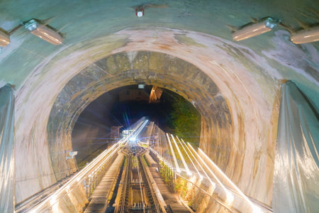 Funicular ride, rails and tunnel en route within tunnel with lights and zoom blur  light trails from...