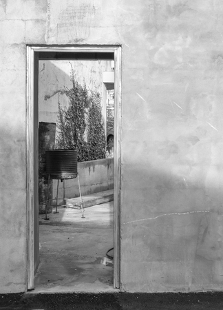Doorway through rustic plastered wall to pation with BBQの写真素材