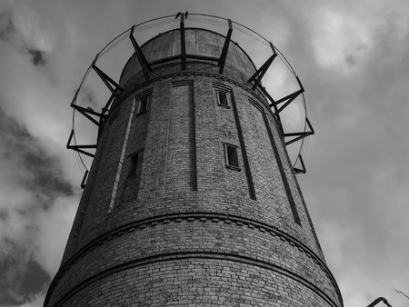 Monochrome against cloudy sky in Cambridge tall orange brick water tower on outskirts of town, New Zealandの写真素材
