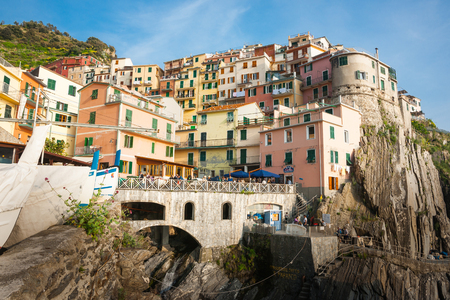MANAROLA ITALY - APRIL25 2011; Boats pulled up below steep colored hillside village buildings built of rock cliff face in Cinque Terre.のeditorial素材