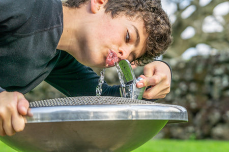 Drinking cool fresh water at water fountain close-up