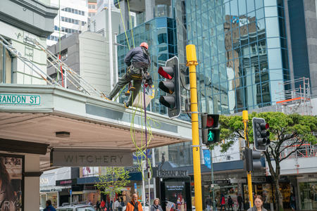 WELLINGTON, NEW ZEALAND - OCTOBER 1 2018; High-rise building exterior cleaners roped and abseiling over veranda to clean building windows.のeditorial素材