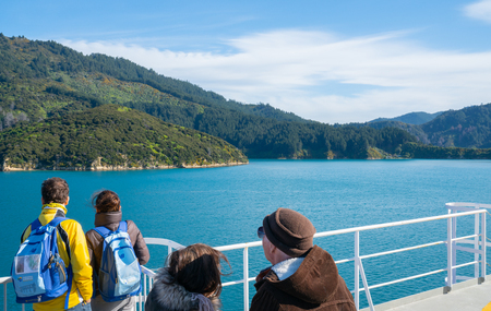 QUEEN CHARLOTTE SOUND NEW ZEALAND - OCTOBER 2 2018; Passengers on-board look at passing scenery arriving in Marlborough Sounds of South Island New Zealand.のeditorial素材