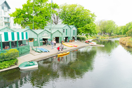 CHRISTCHURCH, NEW ZEALAND - OCTOBER 10 2018; Punting on Avon historic green and white Antigua Boat Sheds along side of river available for people to hire or be puntedのeditorial素材