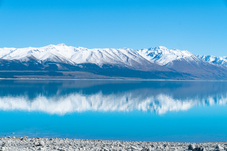 Snow capped mountains reflected in tranquil scenic Lake Pukaki in Mackenzie Basin Canterbury,NZの写真素材