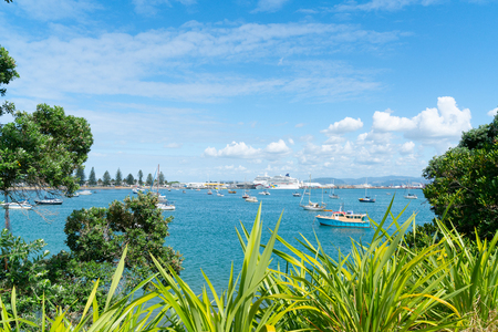MOUNT MAUNGANUI NEW ZEALAND - FEBRUARY 8 2019: Pilot Bay framed by pohutukawa and bright green flax with Cruise ship Norwegian Jewel berthed at wharf.のeditorial素材