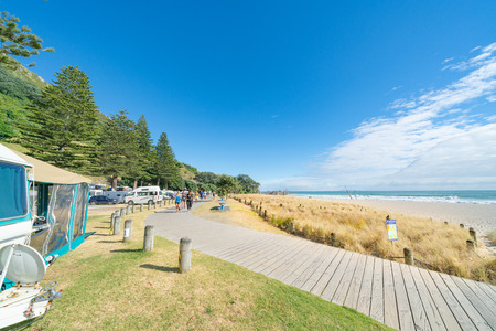 MOUNT MAUNGANUI NEW ZEALAND - FEBRUARY 8 2019: Boardwalk leading to base of Mount Maunganui along in front campers and caravans.のeditorial素材