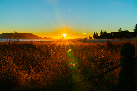 Intense sunrise at Mount Maunganui back lights landscape main beach, Tauranga New Zealand.の写真素材