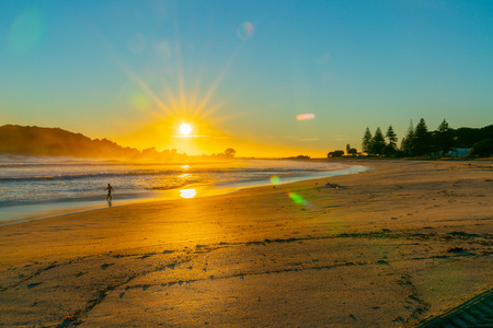 Intense sunrise at Mount Maunganui back lights landscape main beach, Tauranga New Zealand.の写真素材