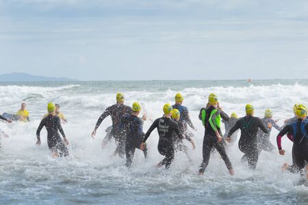 TAURANGA NEW ZEALAND- FEBRUARY 9 2019; Contestants start run into sea  for the Generation Homes Sand to Surf swim event on overcast day.のeditorial素材